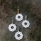 Spider web earrings on a dark textured surface