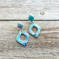 Blue and green marbled earrings on a wooden surface
